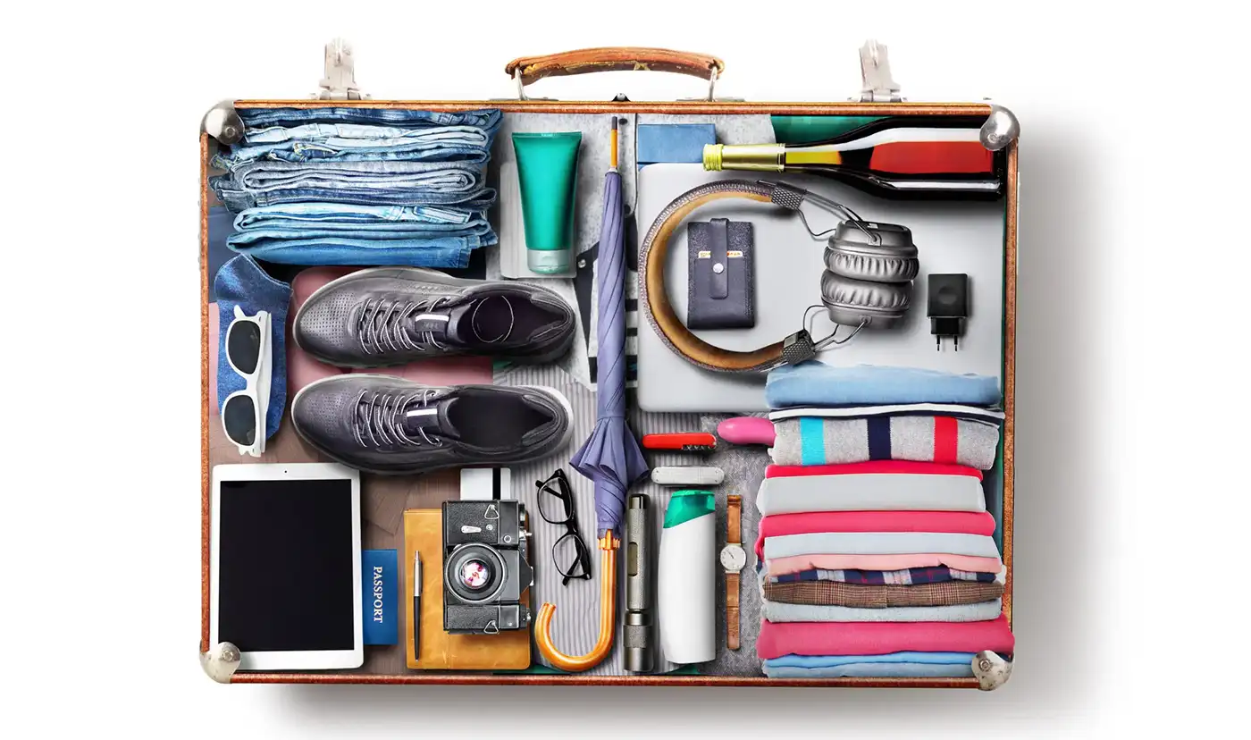 Valise ouverte avec les essentiels de voyage rangés pour la check-list de départ